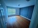 Neutral bedroom showing hardwood floors, wainscoting accent wall, and a double hung window at 2511 Metro Sevilla Dr # 101, Orlando, FL 32835