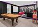 Entertainment room features a pool table, theater screen, and black walls with colorful LED lighting accents at 2560 Shanti Dr, Kissimmee, FL 34746