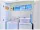 Functional laundry area equipped with a washer, dryer, shelving, and practical storage solutions at 2560 Shanti Dr, Kissimmee, FL 34746