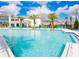 Large community pool surrounded by lounge chairs and palm trees, creating a relaxing resort-style ambiance at 2560 Shanti Dr, Kissimmee, FL 34746