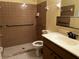 Bathroom featuring walk in shower with safety bars, white vanity and toilet at 26 Palm Run, Ocala, FL 34472