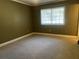 Carpeted bedroom featuring a window offering natural light and ventilation at 26 Palm Run, Ocala, FL 34472