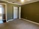 Neutral carpeted bedroom featuring a standard closet with louvered doors for ample storage at 26 Palm Run, Ocala, FL 34472