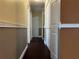 Hallway with hardwood floors, paneled doors, and decorative wall trim at 26 Palm Run, Ocala, FL 34472