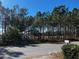 Street view of property surrounded by mature trees, showcasing a tranquil residential setting at 26 Palm Run, Ocala, FL 34472