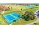 Aerial view of pristine blue tennis courts within a lush community and the surrounding golf course at 2806 Baywood Ln, Kissimmee, FL 34746