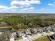 Aerial view of houses on a street with a pond, a dense green forest, and blue sky with clouds at 3245 Upland Pt, Oviedo, FL 32765