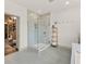 Modern bathroom featuring a glass shower, wood shelving, and entry to large walk-in closet at 3245 Upland Pt, Oviedo, FL 32765