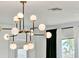 A modern chandelier with spherical lights adds a touch of elegance to the home's decor and brightens the room at 3245 Upland Pt, Oviedo, FL 32765