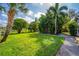 Expansive backyard with lush green grass, mature trees, and a gravel pathway at 328 Lake Fair Ln, Winter Park, FL 32789