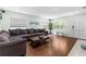 Well-lit living room featuring hardwood floors, a comfortable gray sectional, and neutral decor at 328 Lake Fair Ln, Winter Park, FL 32789