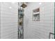 Close-up of a tiled shower with rainfall showerhead and convenient storage niches at 328 Lake Fair Ln, Winter Park, FL 32789