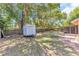 Spacious backyard with mature trees, a picnic table, and a trailer for storage at 3547 Medford Rd, Casselberry, FL 32707
