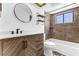 The renovated bathroom features modern fixtures, including a sleek vanity, stylish mirror, and tiled shower-tub combo at 3547 Medford Rd, Casselberry, FL 32707