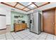 A kitchen area with stainless steel fridge, traditional cabinets, and a skylight providing plenty of natural light at 3547 Medford Rd, Casselberry, FL 32707