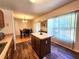 View of the kitchen island, wood floors, and window with shades at 4331 Willowcrest Ct, Orlando, FL 32826