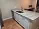 Close-up of kitchen island with granite countertop, sink, and white cabinetry at 5286 Willow Ct # 505, Orlando, FL 32811