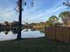 Scenic backyard pond view featuring well maintained lawn and wooden fence at 5286 Willow Ct # 505, Orlando, FL 32811