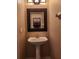 Powder room featuring a pedestal sink, decorative mirror, and vanity for storage at 602 Lochsmere Ln, Orlando, FL 32828