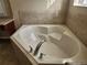 A close up view of a white soaking tub with chrome fixtures and tile surround at 602 Lochsmere Ln, Orlando, FL 32828