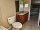 Well-lit bathroom features tiled floors, wood vanity with sink, and a toilet at 602 Lochsmere Ln, Orlando, FL 32828