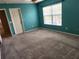 Bedroom with carpet flooring, a ceiling fan, a window with blinds, and teal walls at 602 Lochsmere Ln, Orlando, FL 32828