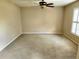 A bedroom with neutral carpet, a ceiling fan, and a window with white blinds at 602 Lochsmere Ln, Orlando, FL 32828