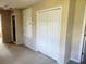 Hallway with a double-door closet and additional storage, all painted in a neutral color at 602 Lochsmere Ln, Orlando, FL 32828