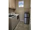 Well-equipped laundry room with washer, dryer, cabinets, and tiled floors at 602 Lochsmere Ln, Orlando, FL 32828