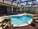 This home's screened pool is surrounded by lush landscaping, a secure safety fence, and brick pavers at 602 Lochsmere Ln, Orlando, FL 32828