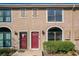 Charming townhome featuring red doors, neutral stucco, and large windows at 606 Casa Park I Court, Winter Springs, FL 32708