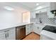 Stylish kitchen with stainless steel dishwasher, white cabinets, and bar area at 606 Casa Park I Court, Winter Springs, FL 32708