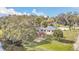 Aerial view of lakeside home with patio, fire pit, and a lush green yard at 632 Tranquil Oaks Ln, Oviedo, FL 32765