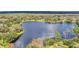 Aerial view of a lakefront property surrounded by lush trees and other homes at 632 Tranquil Oaks Ln, Oviedo, FL 32765