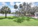 Expansive backyard with lush lawn, mature trees, fire pit, and serene lake views at 632 Tranquil Oaks Ln, Oviedo, FL 32765