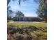 Backyard view of single-story home with a swimming pool and mature trees at 723 Jeffcoat St, Apopka, FL 32703