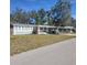 Charming single-story home with a carport, red doors, and lush trees at 723 Jeffcoat St, Apopka, FL 32703