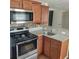 Kitchen featuring stainless steel appliances, granite countertops, and light wood cabinets with modern hardware at 723 Jeffcoat St, Apopka, FL 32703