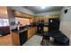 A functional kitchen features light wood cabinets, black appliances and black granite countertops at 7411 Golden Glenn Ct, Orlando, FL 32807