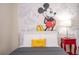 Whimsical bedroom showcasing a playful Mickey Mouse wall design with a cozy bed and bright accents at 8948 Adriatico Ln, Kissimmee, FL 34747