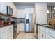 Bright kitchen with stainless steel appliances, tile floors, granite counters, and white cabinets at 8948 Adriatico Ln, Kissimmee, FL 34747