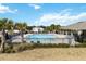 Community pool with lounge chairs and palm trees near clubhouse at 9537 Black Walnut Dr, Clermont, FL 34715