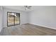 Bedroom featuring modern light gray flooring, a ceiling fan, and a sliding glass door to the yard at 9913 Peddlers Way, Orlando, FL 32817