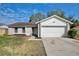 Charming single-story home features an attached two-car garage and a well-maintained front yard at 9913 Peddlers Way, Orlando, FL 32817