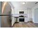 Modern kitchen featuring stainless steel appliances, granite countertops, and sleek white cabinetry at 9913 Peddlers Way, Orlando, FL 32817