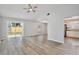 Open-concept living room with sliding glass doors to the backyard and modern gray flooring at 9913 Peddlers Way, Orlando, FL 32817