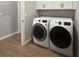 Laundry room featuring a new washer and dryer, wood-look tile floors, and white cabinets at 1038 Commuter Dr, Deltona, FL 32738