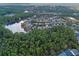 Beautiful aerial view of community homes bordering lush forest and a tranquil lake at 1112 Heron Point Way, Deland, FL 32724