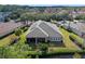 Aerial view of home featuring solar panels, screened patio and lush greenery at 1112 Heron Point Way, Deland, FL 32724