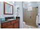 Bright bathroom with a glass shower, dark wood vanity, and light blue walls at 1112 Heron Point Way, Deland, FL 32724